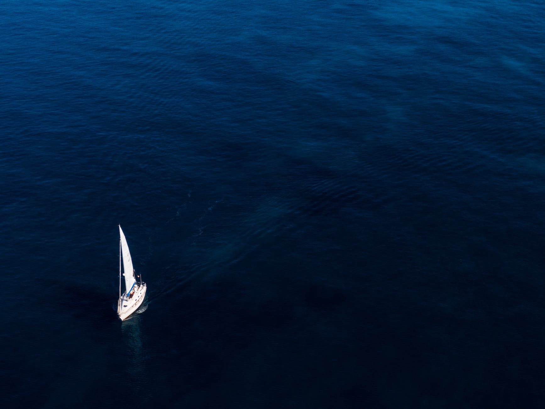 white boat sailing on body of water